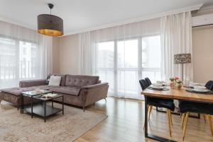 a living room with a couch and a table at Large Apartment in Gdańsk with Gym, Parking and Air Conditioning by Noclegi Renters in Gdańsk +18 photos