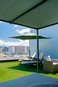 two chairs and an umbrella on the roof of a building at The Blue Calla in Las Palmas de Gran Canaria