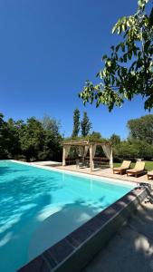 a large swimming pool with chairs and a picnic shelter at Casa Boutique con piscina y cercana a plaza de Villa de las Rosas in Villa de Las Rosas