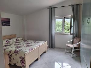 a bedroom with a bed and a window and a chair at Casa Vacanze Angelo in Palinuro