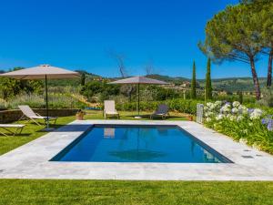 a swimming pool in a yard with umbrellas at Holiday Home Casa Aia by Interhome in Corti