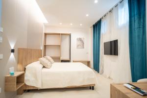 a bedroom with a bed and a tv on a wall at B&B Villa M S in Crotone