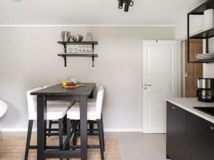 a black dining room table with white chairs in a kitchen at Holiday Home Dejarp Stugan by Interhome in Ängalag