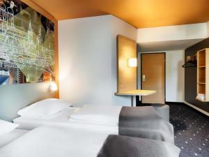 a hotel room with a bed and a chair at B&B Hotel München-Hbf in Munich