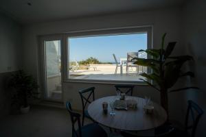 a table and chairs in a room with a large window at B&B Villa M S in Crotone