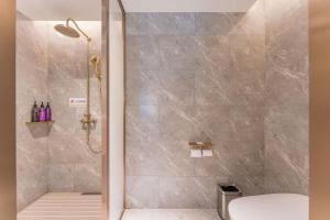 una ducha con puerta de cristal en un baño en Mercure Hotel Hangzhou East Railway Station, en Hangzhou 60 fotos más
