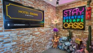 a sign on a brick wall with a tv on it at Sokcho HOTEL OASIS in Sokcho