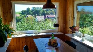 a dining room with a table and a large window at Ferienhaus Landblick in Bad Arolsen
