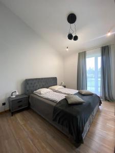 a bedroom with a bed and a large window at Family house in Valmiera