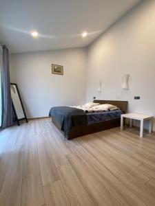 a bedroom with a bed and a table on a wooden floor at Family house in Valmiera
