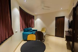 a living room with a blue couch and chairs at Kings Executive and Restaurant in Tuljapur