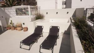 two black chairs sitting on a balcony with plants at PH en La Plata con terraza in La Plata +4 photos