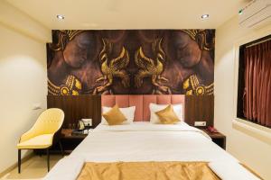 a bedroom with a large bed with a painting on the wall at Kings Executive and Restaurant in Tuljapur +23 photos