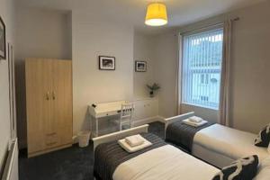 a bedroom with two beds and a desk and a window at Hambledon Apartment - Sleeps 3 - Pet friendly in Blythe