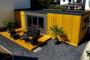 een geel gebouw met twee stoelen en een tafel bij Tiny House mit Terrasse und Garten in Altstadtnähe inkl Parkplatz in Weiden