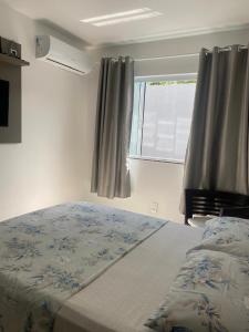 a bedroom with a bed and a window with curtains at Apto ideal entre Aeroporto, a Praia e o Beto Carrero in Navegantes