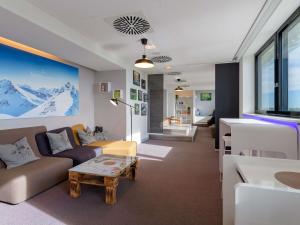 a living room with a couch and a table at Novotel München Airport in Freising