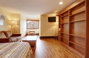 a bedroom with a bed and a couch and a tv at VS553 Village Square Hotel Room Hotel Room in Wheeler Junction