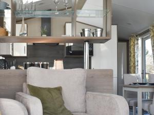 Una sala de estar con una silla y una mesa. en West Mersea Park, en West Mersea