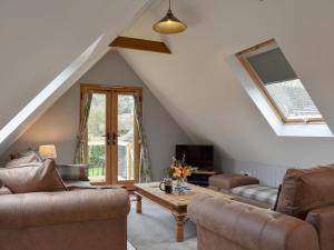 a living room with two couches and a table at The Haybarn in Woolland