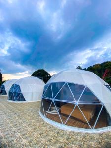 two domed tents in a field under a cloudy sky at Baith Glamping Dome in Cihideung