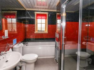 a bathroom with a sink and a toilet and a bath tub at Alpaca cabin-mountain view-hot tub-rural retreat in Llanbrynmair
