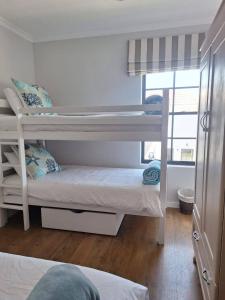 Habitación compartida con 2 literas y ventana en Foam House, en Bloubergstrand 4 fotos más