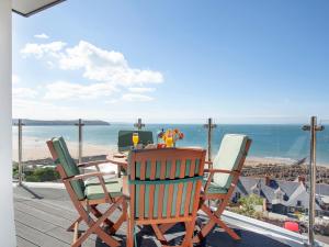 einen Tisch und Stühle auf einer Terrasse mit Meerblick in der Unterkunft Soft Sands - Cottage in Woolacombe