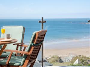 ein Tisch und Stühle mit Blick auf den Strand in der Unterkunft Soft Sands - Cottage in Woolacombe + 34 Fotos