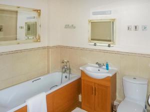 a bathroom with a tub and a sink and a toilet at Royds Hall Cottage in Keighley
