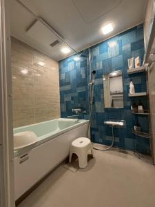 a bathroom with a tub and a toilet in it at 島時間 Yagaji Village in Wada