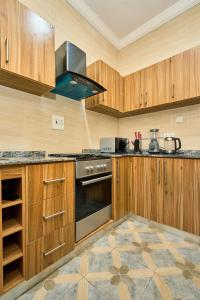 a kitchen with wooden cabinets and a stove top oven at Shabi's Court in Lagos
