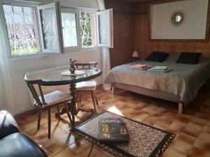 a bedroom with a bed and a table and windows at L'Alsace d'ANTAN in Strasbourg