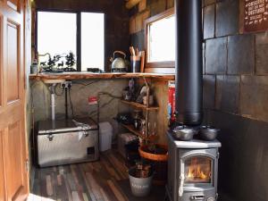 a kitchen with a wood burning stove in a room at Deer Close - Uk45787 in Millom