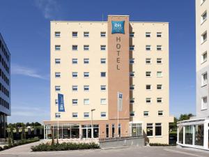 a large white building with a sign on it at ibis Budget Luxembourg Sud in Livange