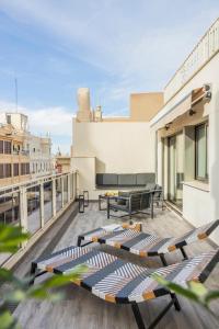 a balcony with lounge chairs on top of a building at Room Mate Cosmo - City Centre, Valencia in Valencia