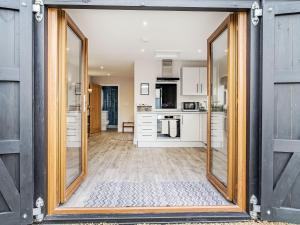 an open door into a kitchen with white cabinets at Wisteria Lodge - Ukc5804 in Shelfanger