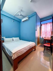 a blue bedroom with a bed and a desk at The Skydeck in Havelock Island