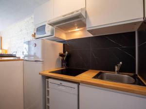 a kitchen with a sink and a refrigerator at Charmant Appartement 6 Pers, Pieds des Pistes avec Navette, Parking Gratuit - FR-1-695-35 in Germ