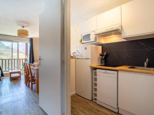 a kitchen with white appliances and a dining room with a table at Charmant Appartement 6 Pers, Pieds des Pistes avec Navette, Parking Gratuit - FR-1-695-35 in Germ