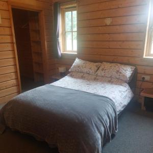 a bedroom with a bed in a wooden cabin at Alpaca cabin-mountain view-hot tub-rural retreat in Llanbrynmair