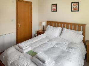 a white bed with towels on top of it at 1 Lonsdale House in Keswick