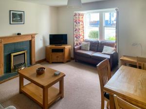 a living room with a couch and a fireplace at 1 Lonsdale House in Keswick