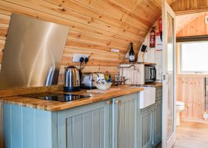 a kitchen with wooden walls and a counter top at Lowside Farm Glamping in Troutbeck