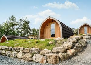 a small wooden house with a pile of rocks at Lowside Farm Glamping in Troutbeck