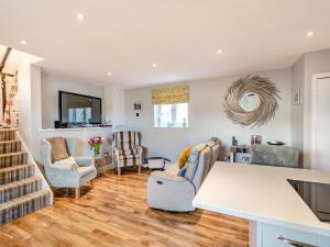 a kitchen and living room with a table and chairs at Brittons Hill Cottage in Wavehorne