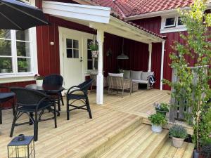 a wooden deck with a table and chairs on a house at Kyrkliden in Torestorp