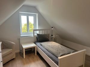 a bedroom with a bed and a chair and a window at Fehmarn in Fehmarn