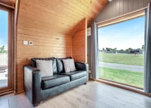 un divano in pelle in una camera con una grande finestra di South View Retreat a Carlton