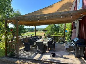 a wooden deck with a table and chairs and a tv at Kyrkliden in Torestorp